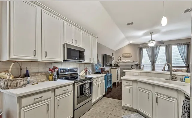 a kitchen with white cabinets and white appliances