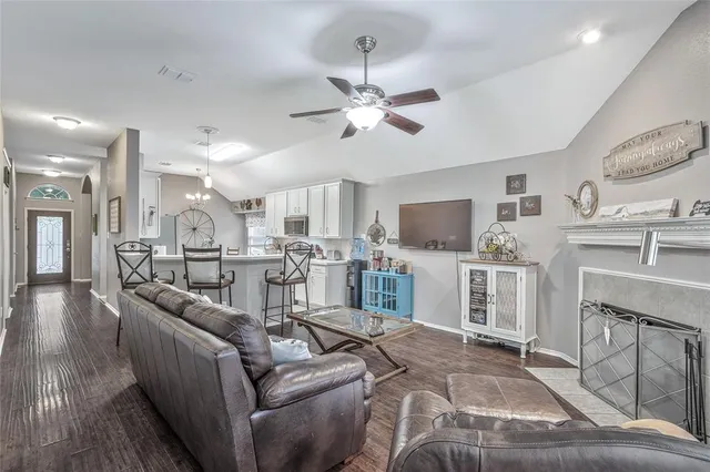 a living room with furniture a flat screen tv and kitchen view