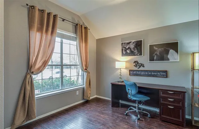 a view of a workspace with furniture and a window
