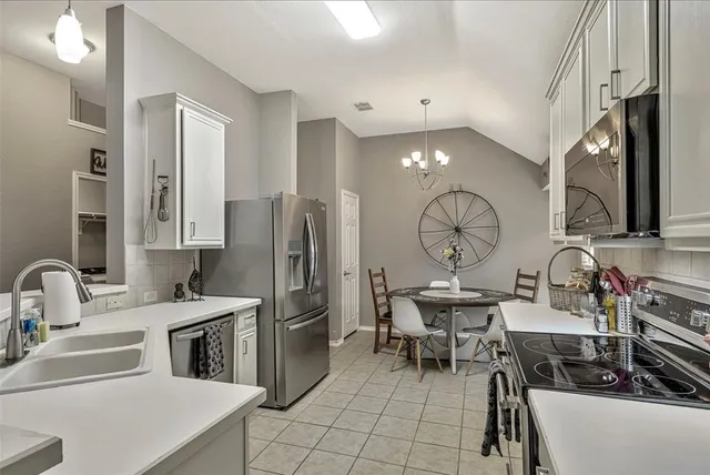a kitchen with stainless steel appliances a sink cabinets and a refrigerator