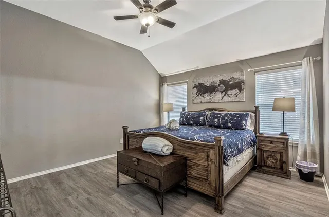 a bed sitting in a bedroom next to a window with a bookshelf