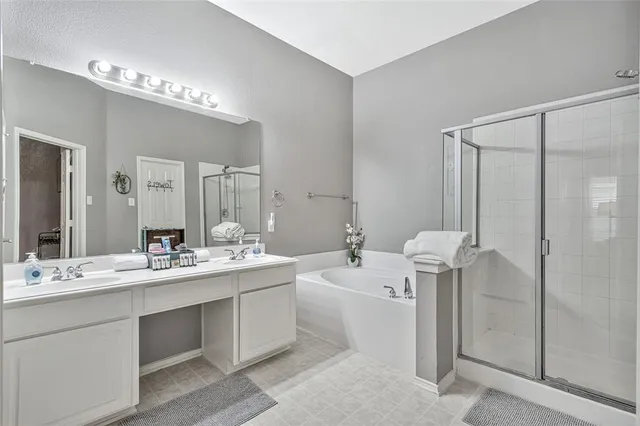 a bathroom with a double vanity sink mirror and shower