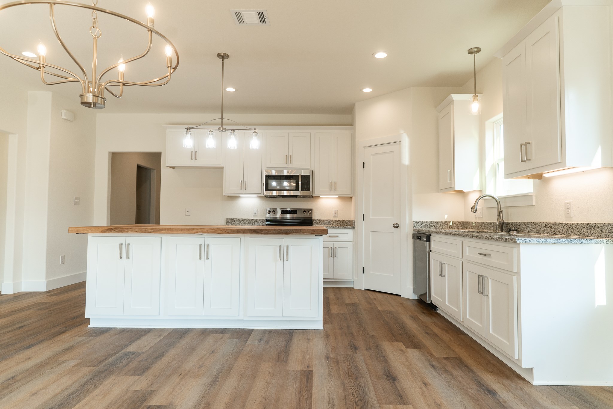309 String Prairie Way Smithville, TX 78957 - Photo 12 of 30 a kitchen with granite countertop white cabinets and white appliances