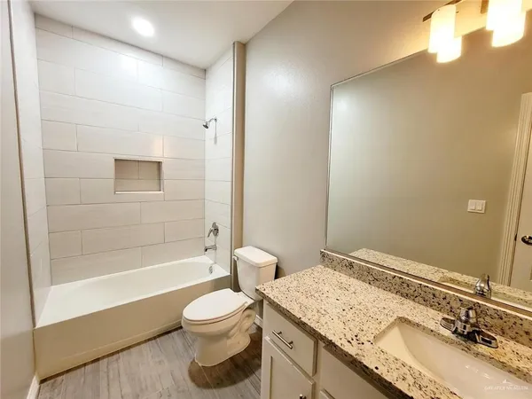a bathroom with a granite countertop sink toilet and shower