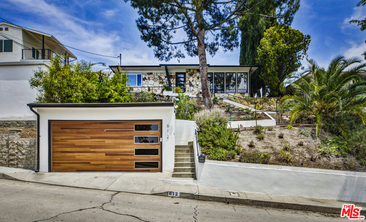 a front view of a house with a garden
