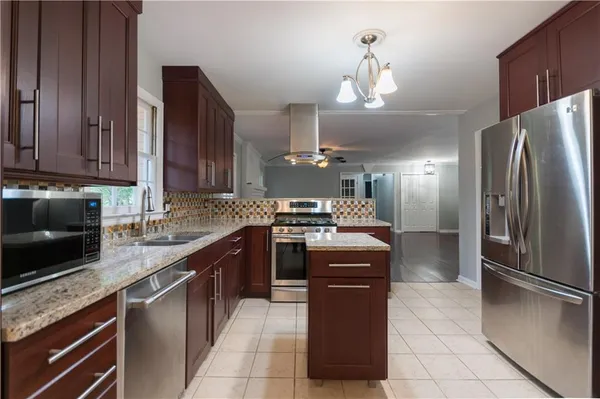 a kitchen with stainless steel appliances granite countertop a stove a refrigerator and a sink