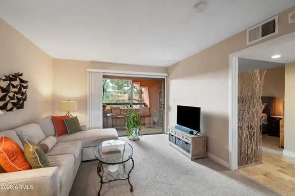 a living room with furniture a flat screen tv and a large window