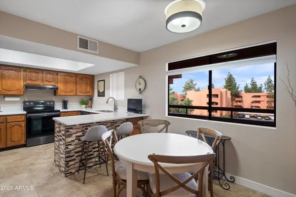 a large kitchen with a table and chairs