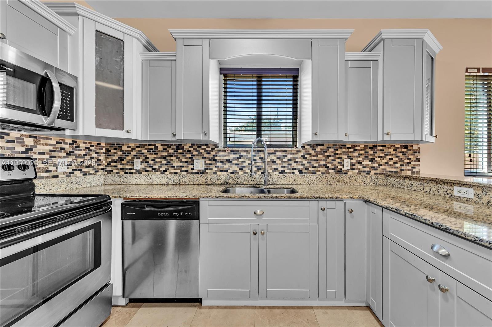 4025 Southwest 10th Street Miami, FL 33134 - Photo 12 of 41 a kitchen with sink cabinets and stainless steel appliances