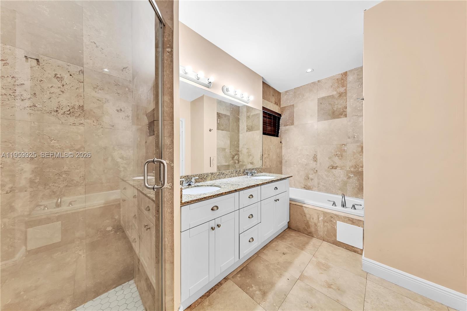 4025 Southwest 10th Street Miami, FL 33134 - Photo 27 of 41 a bathroom with a granite countertop sink a mirror and a bathtub