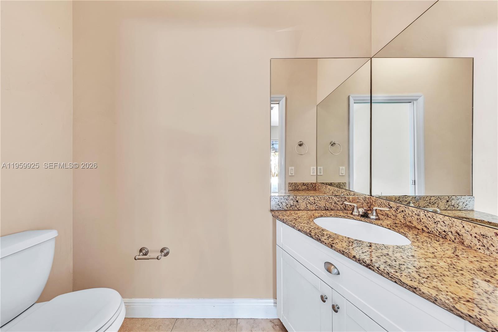 4025 Southwest 10th Street Miami, FL 33134 - Photo 10 of 41 a bathroom with a granite countertop sink a mirror and a toilet
