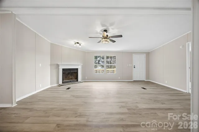 a view of an empty room with a fireplace and a window