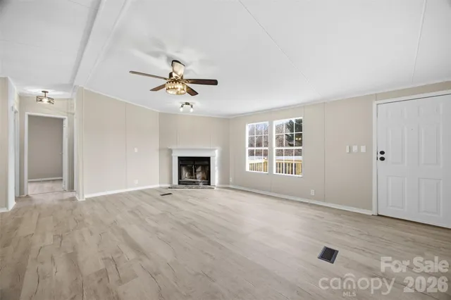 a view of an empty room with a fireplace and a window