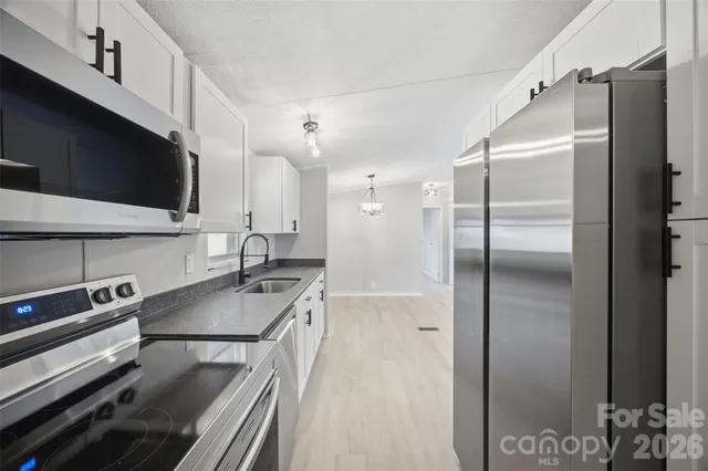 a kitchen with stainless steel appliances granite countertop a refrigerator and a sink