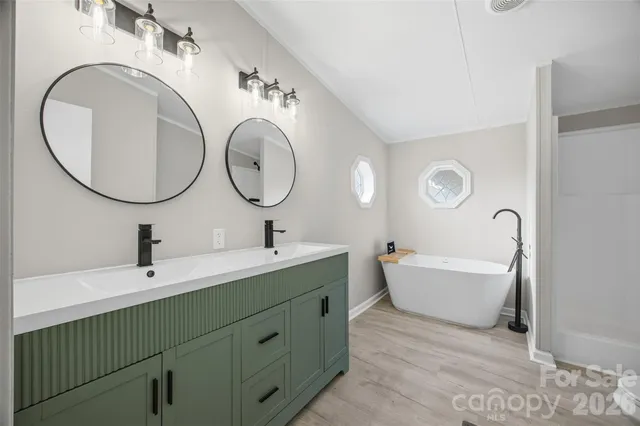 a bathroom with a double vanity sink mirror and bathtub