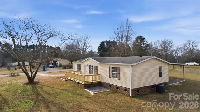 a view of white house with a yard and wooden fence