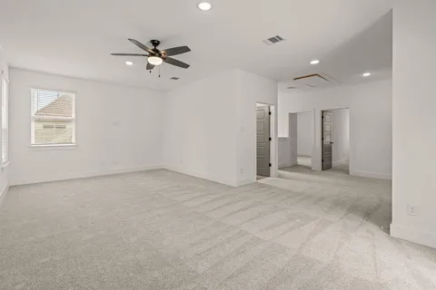 an empty room with windows and fan