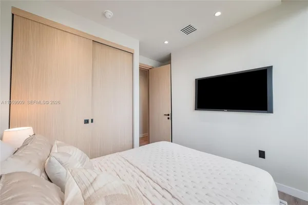 a bedroom with a bed and a flat screen tv