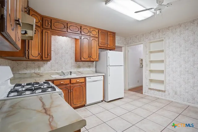 a kitchen with stainless steel appliances granite countertop a refrigerator and a stove top oven