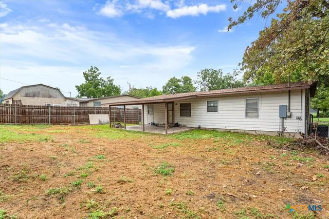a backyard of a house with table and chairs
