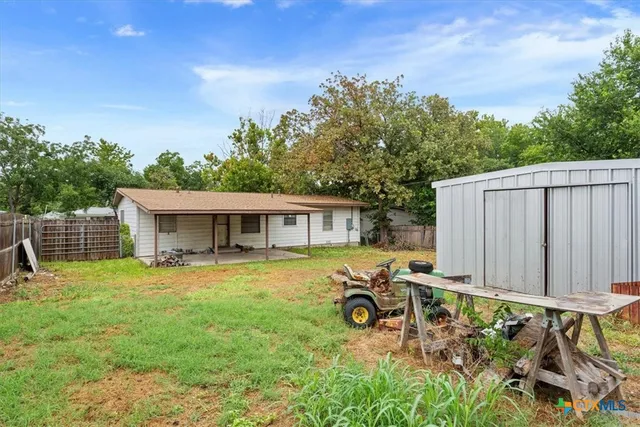 a view of a house with backyard and sitting area
