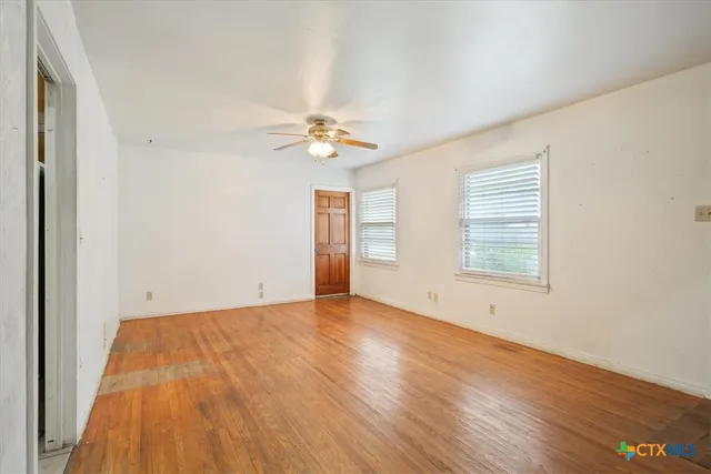 wooden floor in an empty room with a window