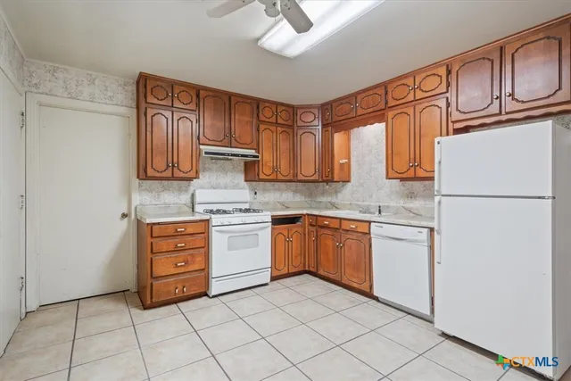 a kitchen with stainless steel appliances granite countertop a refrigerator sink and cabinets