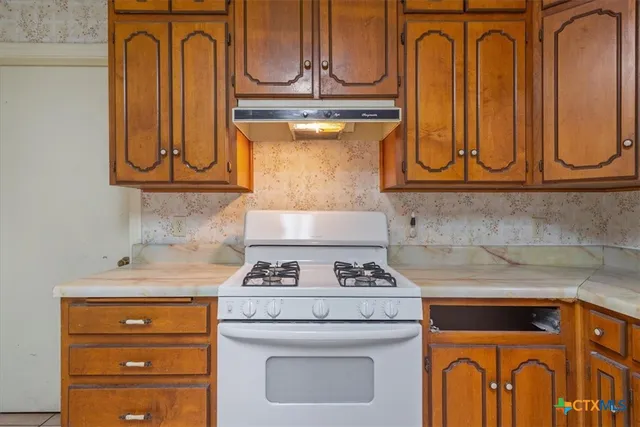 a kitchen with granite countertop cabinets and black appliances