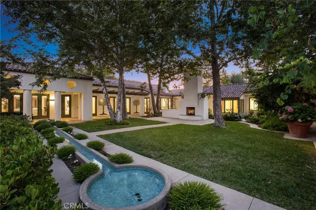 a backyard of a house with barbeque oven fire pit table and chairs