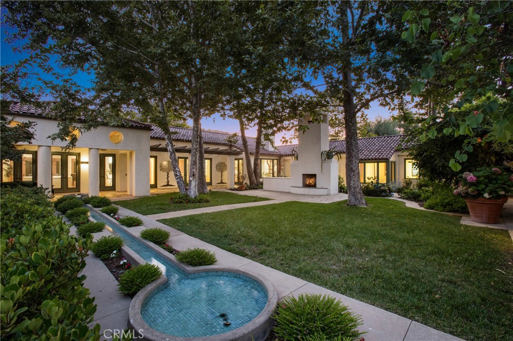 a backyard of a house with barbeque oven fire pit table and chairs