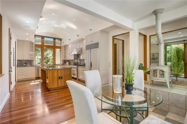 a dining room with stainless steel appliances kitchen island granite countertop a dining table chairs and view living room