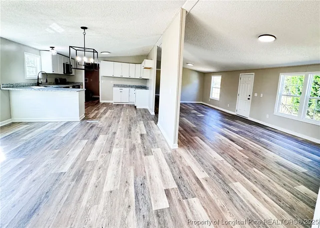 a view of a kitchen with wooden floor and electronic appliances