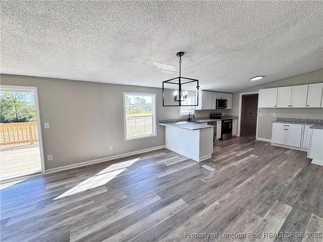 a view of a kitchen with a sink a refrigerator and window