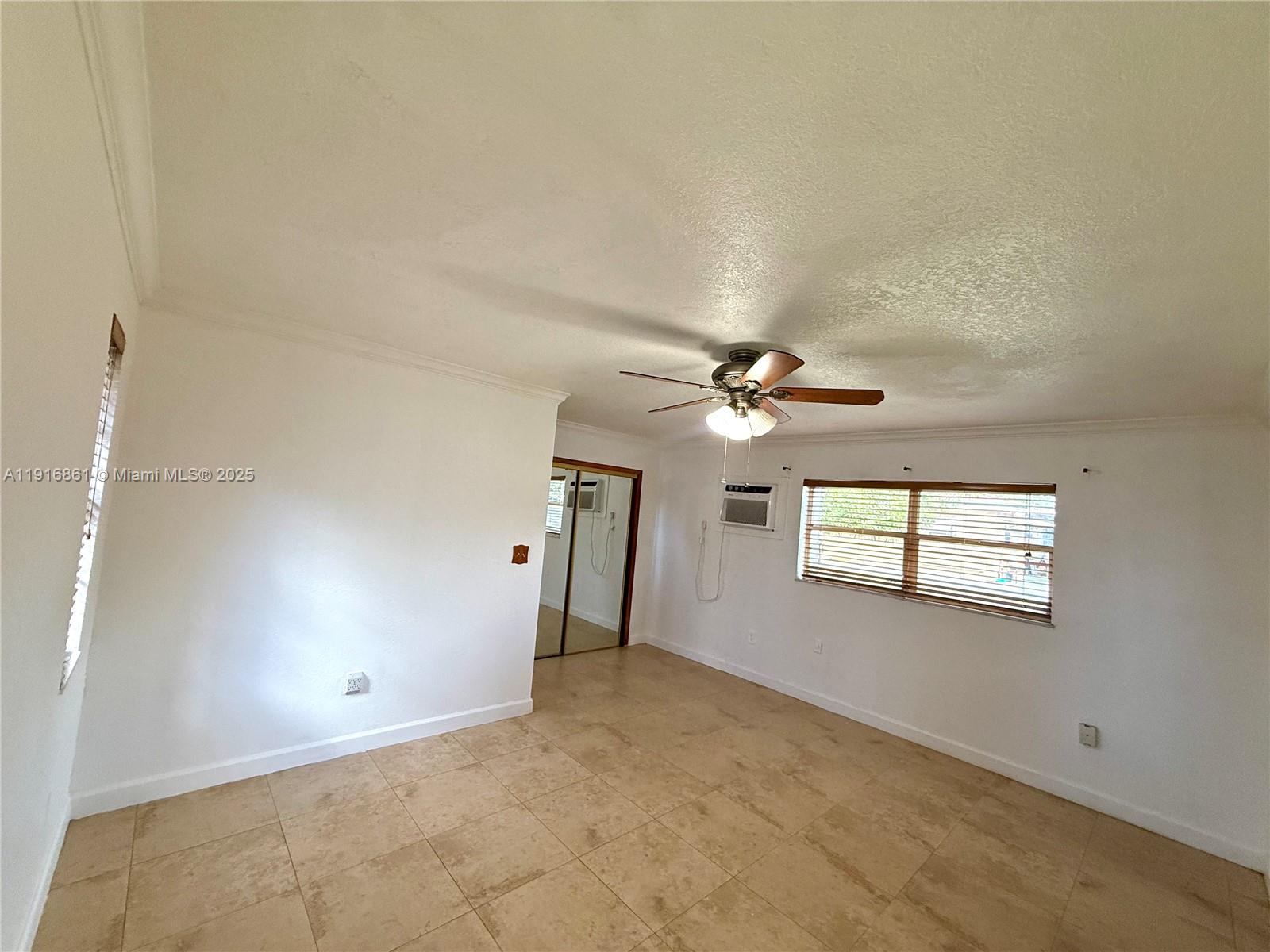 174 East 41st Street Hialeah, FL 33013 - Photo 20 of 46 an empty room with windows and fan