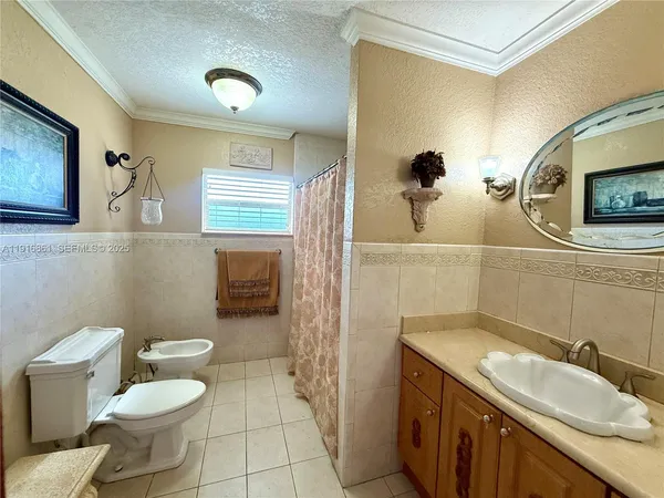 a bathroom with a granite countertop toilet sink and mirror