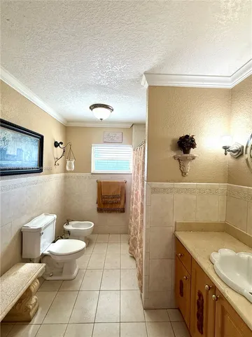 a bathroom with a granite countertop sink a toilet a mirror and shower