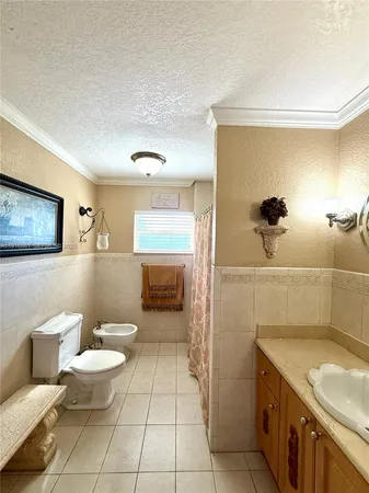 a bathroom with a granite countertop sink a toilet a mirror and shower