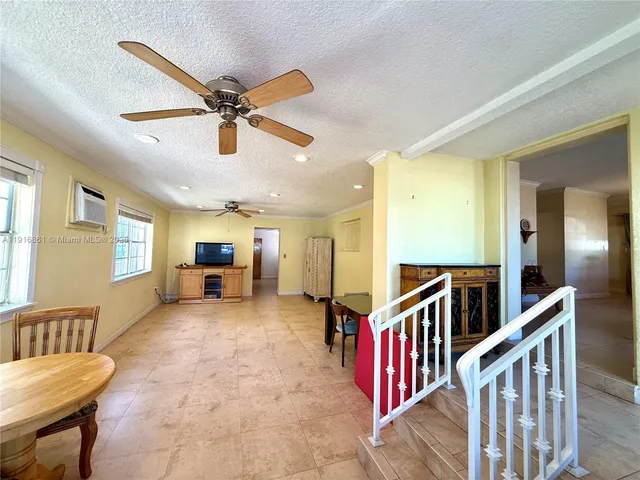 a living room with furniture and a ceiling fan