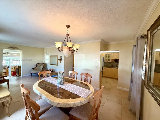 a dining room with furniture a chandelier and window