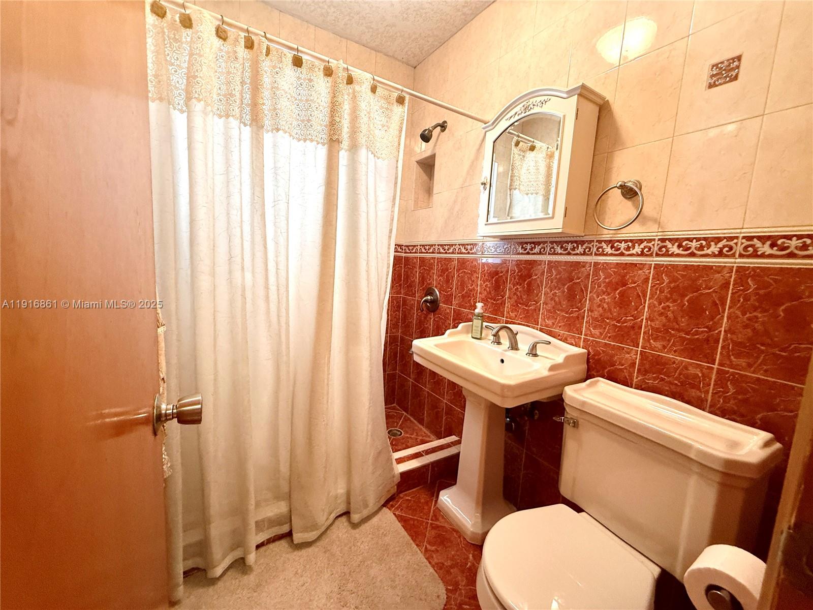 174 East 41st Street Hialeah, FL 33013 - Photo 45 of 46 a bathroom with a sink a toilet mirror and shower