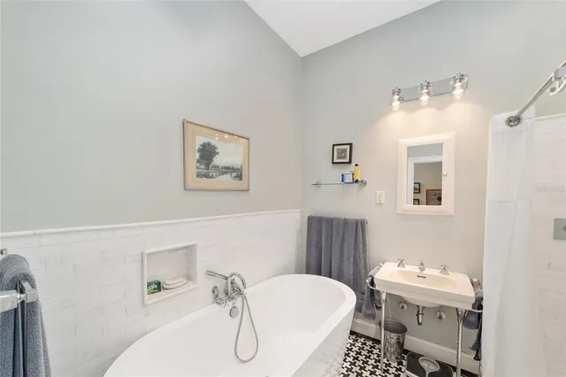 a bedroom with a large bed and a chandelier