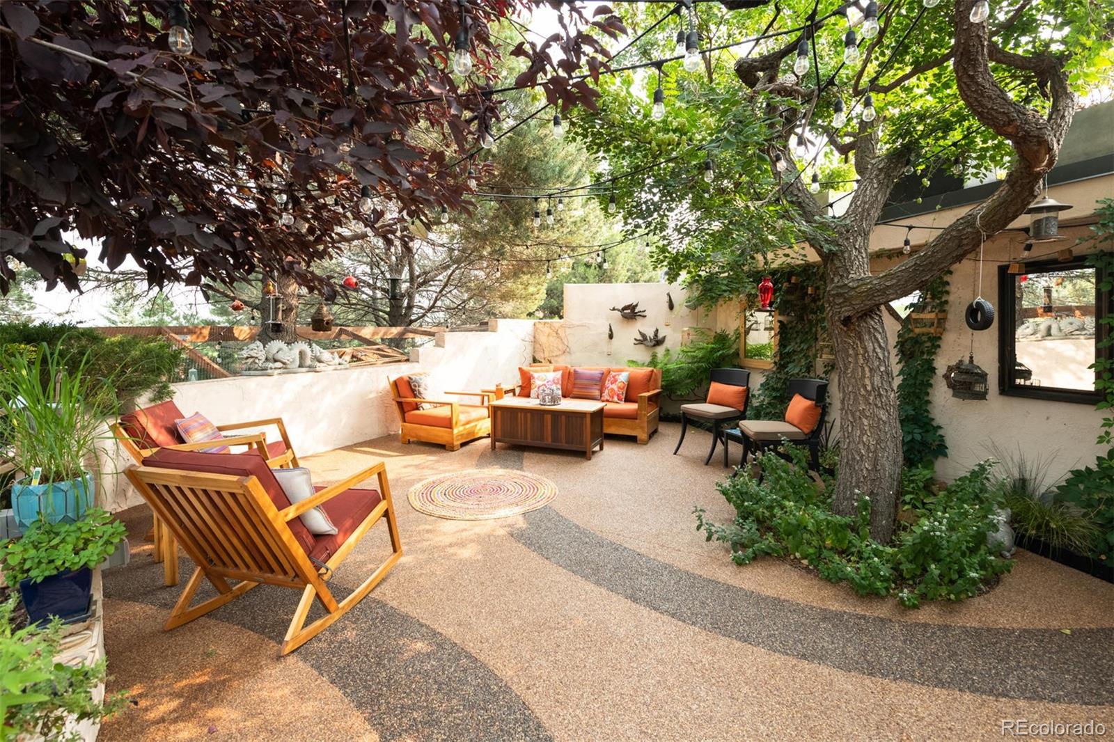 415 Drake Street Boulder, CO 80305 - Photo 22 of 40 a view of a patio with couches and a table and chairs with wooden fence and large trees