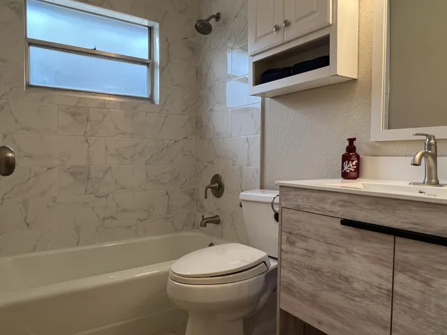 a bathroom with a sink a toilet and shower