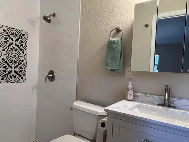 a white toilet sitting next to a bathroom sink