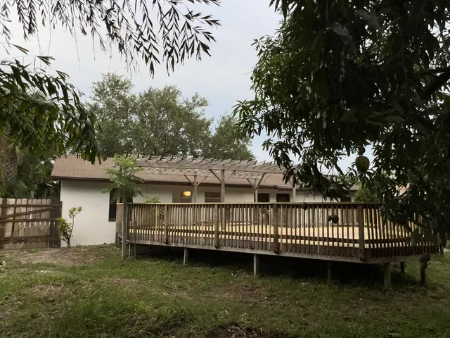 a view of a house with backyard and trees