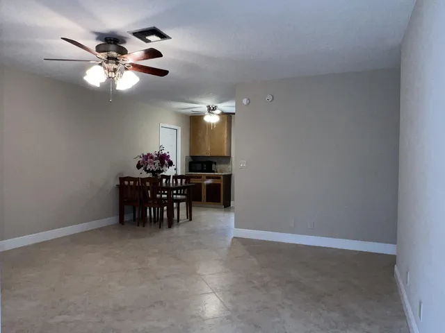 a view of a dining room with furniture and chandelier fan