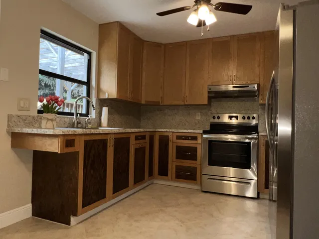 a kitchen with kitchen island a sink stainless steel appliances and cabinets