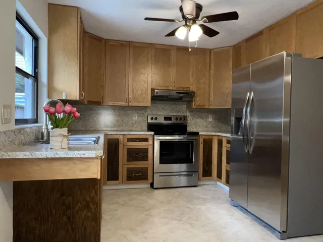 a kitchen with kitchen island granite countertop stainless steel appliances and a counter space