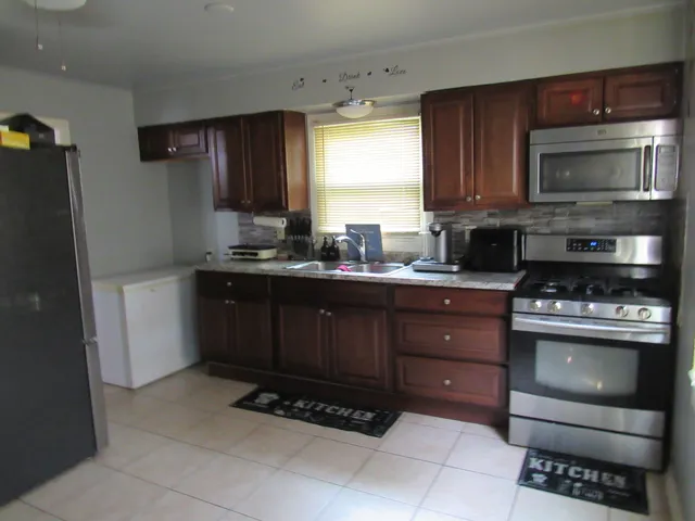 a kitchen with stainless steel appliances granite countertop a stove a sink and a microwave