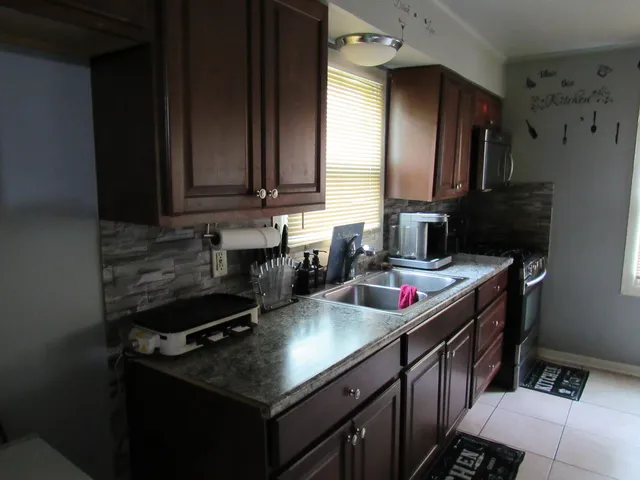 a kitchen with stainless steel appliances granite countertop a sink stove and cabinets